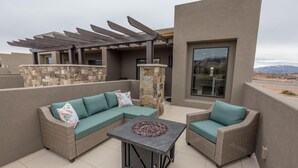 A patio with a sectional sofa, a small table, and a pergola. - Canyon Views (St. George)