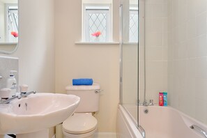 A bathroom with a sink, toilet, and bathtub.