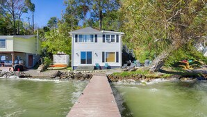 Una casa de dos pisos con un muelle que da al río.