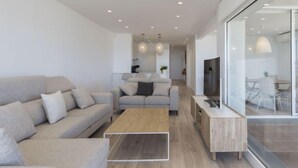 Un salon moderne avec un canapé, une table basse et un téléviseur.