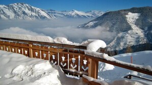 A wooden railing with snow-covered railings and a mountainous landscape in the background. - T-Resort La Tzoumaz 3p6 vue vallée by Interhome (La Tzoumaz)