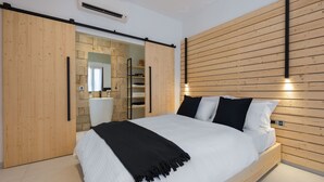 Quarto moderno com cama grande, cabeceira de madeira e guarda-roupa de correr.