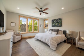 A bedroom with a large bed, a ceiling fan, and two windows. - I'm Your Huckleberry at Lake Chelan Lookout Vacation Rentals (Chelan)