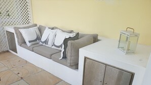A white sofa with grey cushions and a white cabinet with a metal door. - 4-STAR-Apartment (AA Superior rated) at the Constantia Wine Route / Kapstad (Constantia)