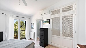 A bedroom with a bed, a wardrobe, a radiator, and a balcony with curtains. - Fantastic villa with pool in Betlem (Arta Betlem)