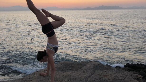 A person performing a handstand on a rocky beach with a sunset in the background. - Fantastic villa with pool in Betlem (Arta Betlem)