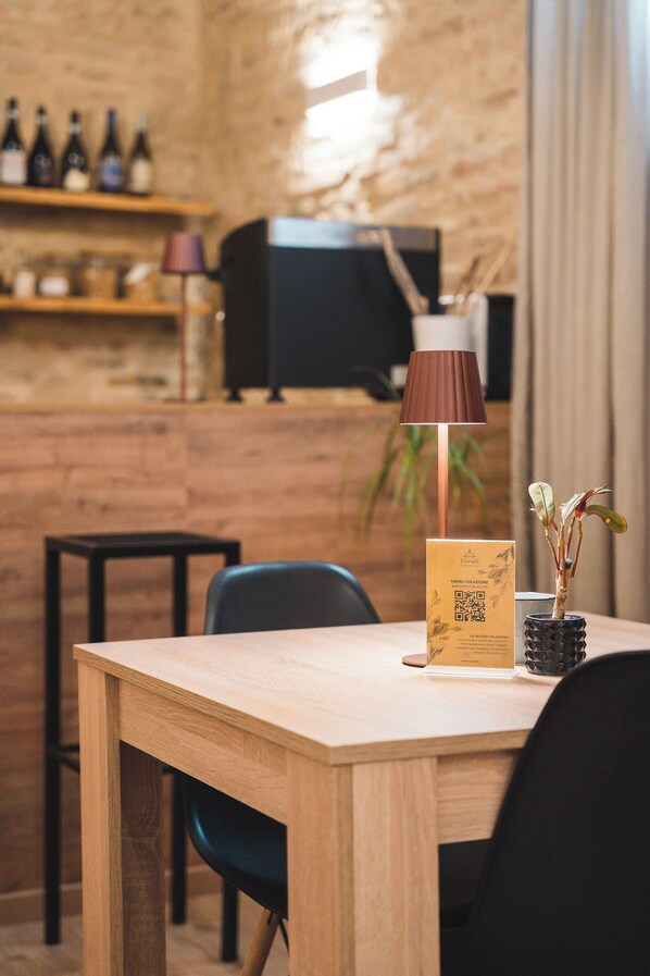 A wooden table with a menu, a lamp, and a vase with plants.