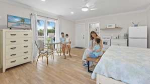 Una sala de estar amplia con comedor, cocina y un dormitorio.