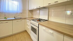 Uma cozinha moderna com armários brancos, um fogão e uma pia.