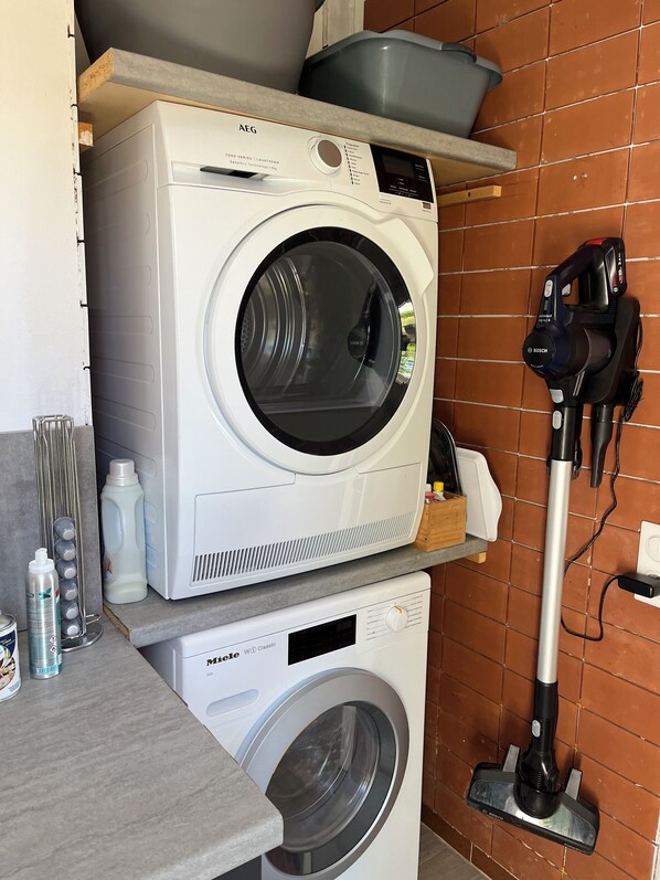 A compact laundry area with a Bosch washing machine and a Bosch vacuum cleaner. - Private swimming pool, private pétanque court. Fully enclosed grounds. (Meschers-sur-Gironde)