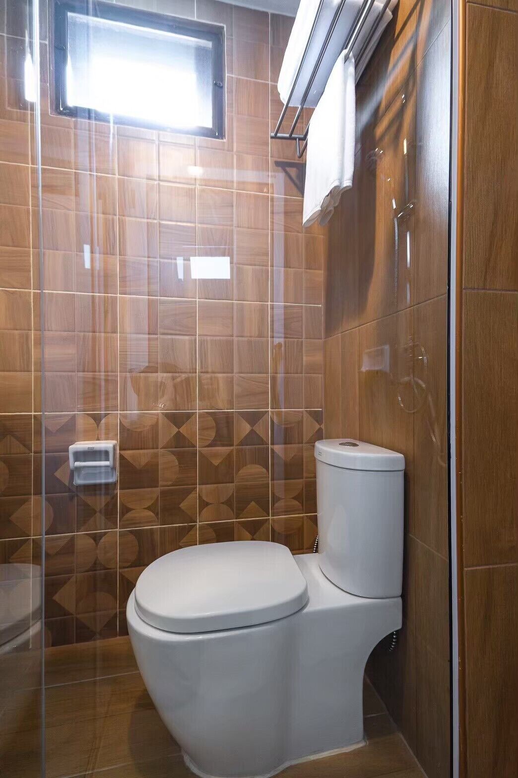 Un baño moderno con inodoro, secamanos y toallero.
