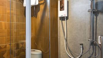 Un baño moderno con ducha de vidrio, inodoro y perchero para toallas.