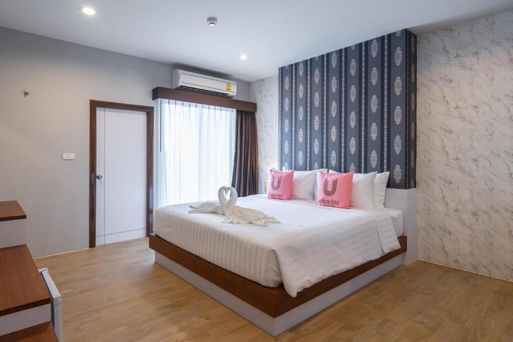 Een hotelkamer met een groot bed, een garderobe en een raam met gordijnen.