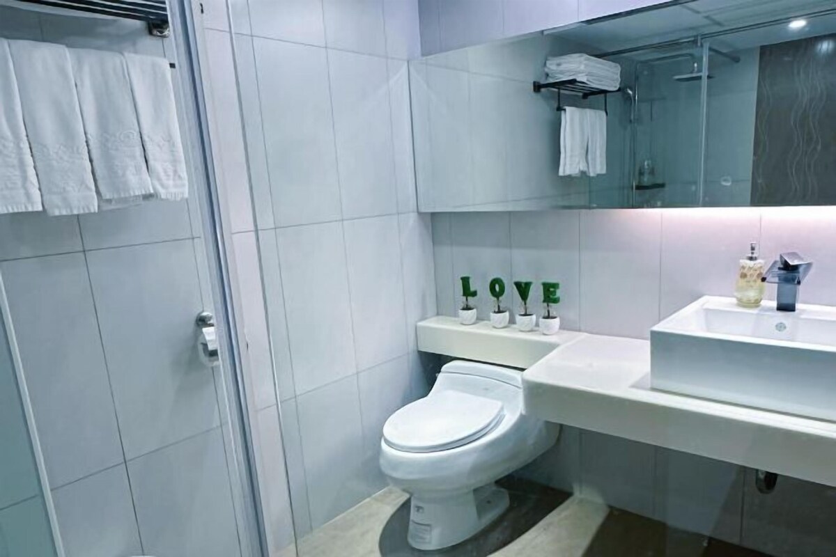 Un baño moderno con inodoro, lavamanos y ducha.