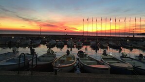 A marina with multiple boats docked at low tide, a clear sky, and a sunset. - Casa Davide-Apartment in Bardolino (Bardolino)