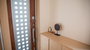 A wooden door with a grid pattern, a small round mirror on a wooden surface, and a cabinet with drawers. - Pine House in ISHIGAKI (Ishigaki)