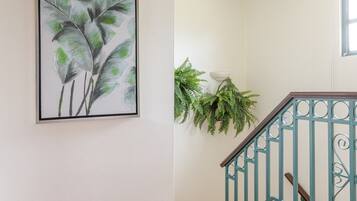 A staircase with a handrail and a wall-mounted plant.