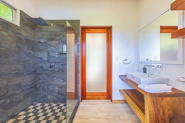 A modern bathroom with a stone shower, a wooden vanity, and a large mirror. - Vista Azul-Charming Villa with Splendid Ocean Views,Gated Community,Private Pool (Savegre)