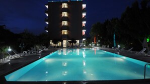 A swimming pool with lounge chairs and a building in the background. - Bellissima Hotel (Manavgat)
