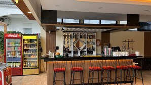 A bar area with a counter, bar stools, and a variety of bottles. - Bellissima Hotel (Manavgat)