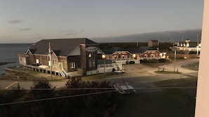 Un hotel frente al mar con varias construcciones y vista a la playa, con un letrero que dice 'Ocean Air'.