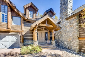 A log cabin with a stone chimney, a wooden front door, and a garage. - Estate on 5 acres | 3.5 mi to Main St | Hot Tub! (Breckenridge)