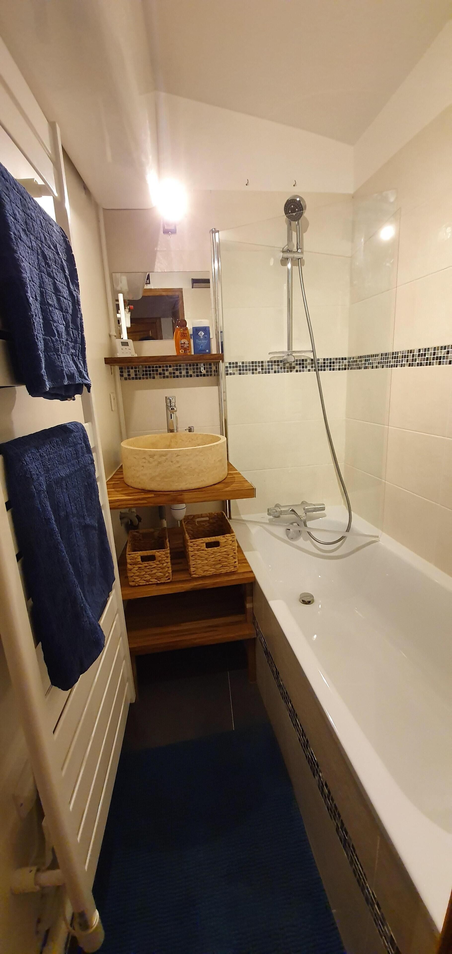 A compact bathroom with a bathtub, a shower, and a sink.