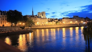 A nighttime view of the Notre-Dame Cathedral in Paris, reflecting on the Seine River. - Warm appartment in the center of historical Paris with full equipment (Paris)