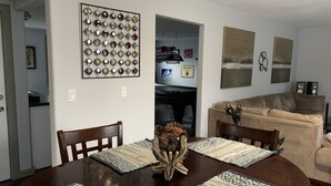 Un comedor con una mesa de madera, cuatro sillas y un centro de mesa decorativo.