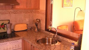 A kitchen with a stainless steel sink, a toaster, a coffee maker, and a microwave. - FIRST LINE BEACH LUXURY APARTMENT. SEA VIEWS (Ayamonte)