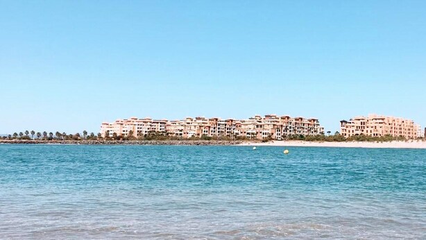 A beachfront hotel with multiple buildings, a sandy beach, and calm sea. - FIRST LINE BEACH LUXURY APARTMENT. SEA VIEWS (Ayamonte)