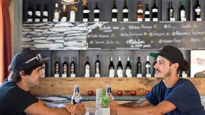Two people seated at a wooden table in a bar setting with a wine rack in the background. - T-Resort La Tzoumaz 2p4 vue vallée by Interhome (La Tzoumaz)