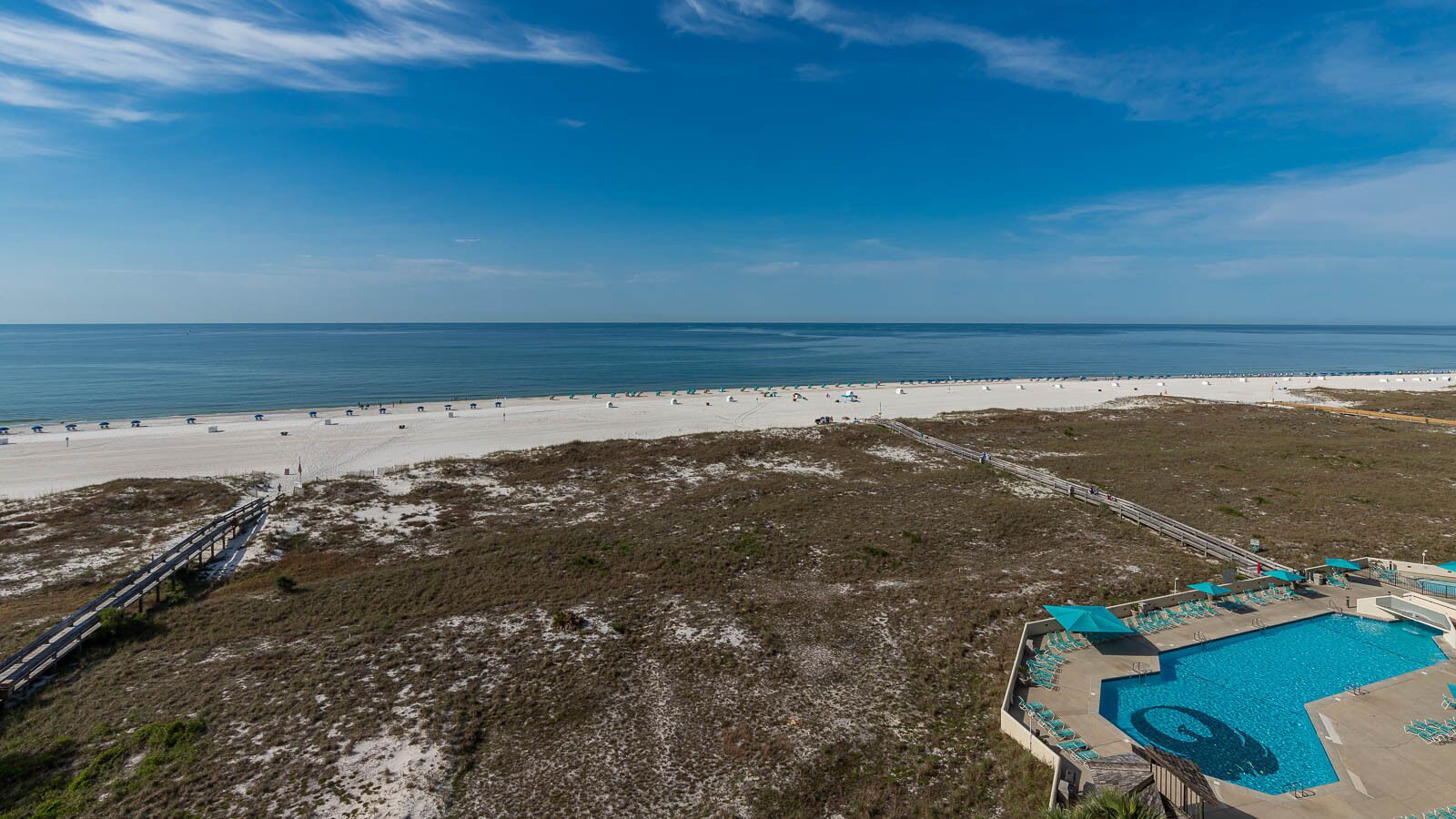 Un complexe hôtelier de bord de mer doté d’une piscine, d’un accès à la plage et d’une promenade en bord de mer.