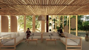 Un salon moderne avec un plafond en bois, de grandes fenêtres et une vue sur la verdure. On y trouve deux canapés et une table basse.