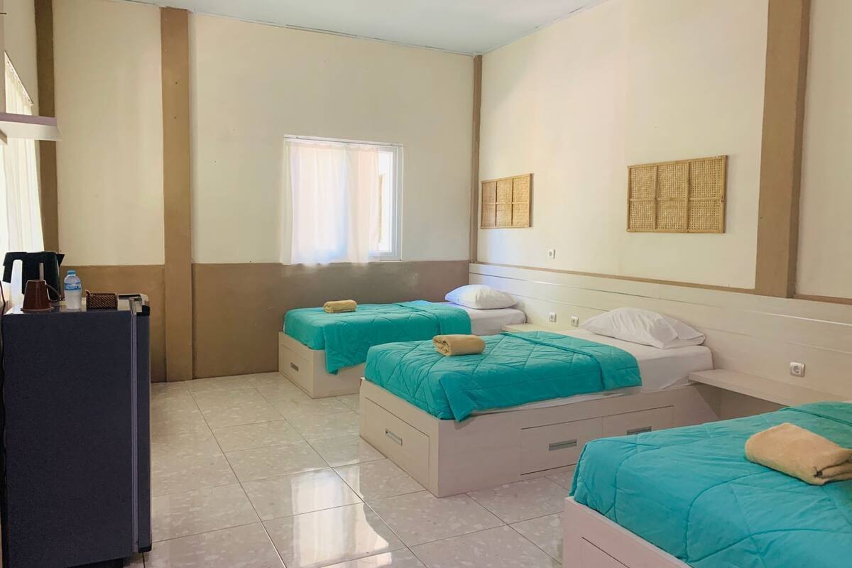 Een hotelkamer met twee bedden, een bureau en een raam.