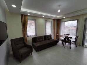 Deluxe-huoneisto, 1 makuuhuone, osittainen järvinäköala | Oleskelualue | 43–tuumainen plasmatelevisio, jossa satelliittikanavat