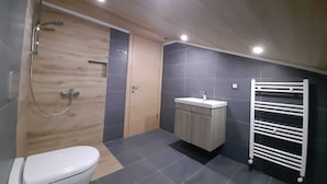 Un bagno moderno con un mobile vanitario in legno, un water bianco, una doccia e un porta asciugamani.
