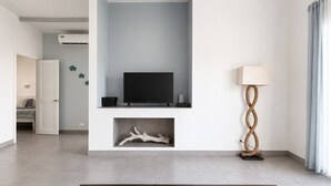En moderne stue med et fladskærms-tv, en dekorativ lampe og trægulv.