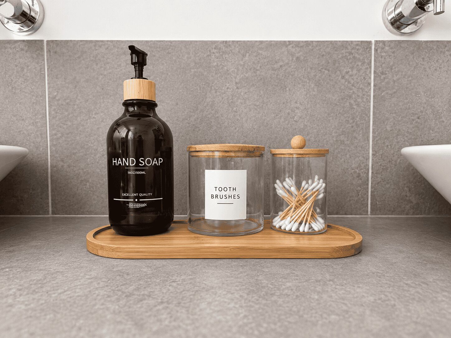 Un meuble-lavabo de salle de bain avec un distributeur de savon liquide, un récipient étiqueté « BROSSES À DENTS » et un pot contenant des cotons-tiges.