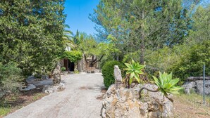 A paved pathway leading to a building surrounded by trees and rocks. - CAN COMPANY - Villa with private pool in Campanet. Free WiFi (Campanet)