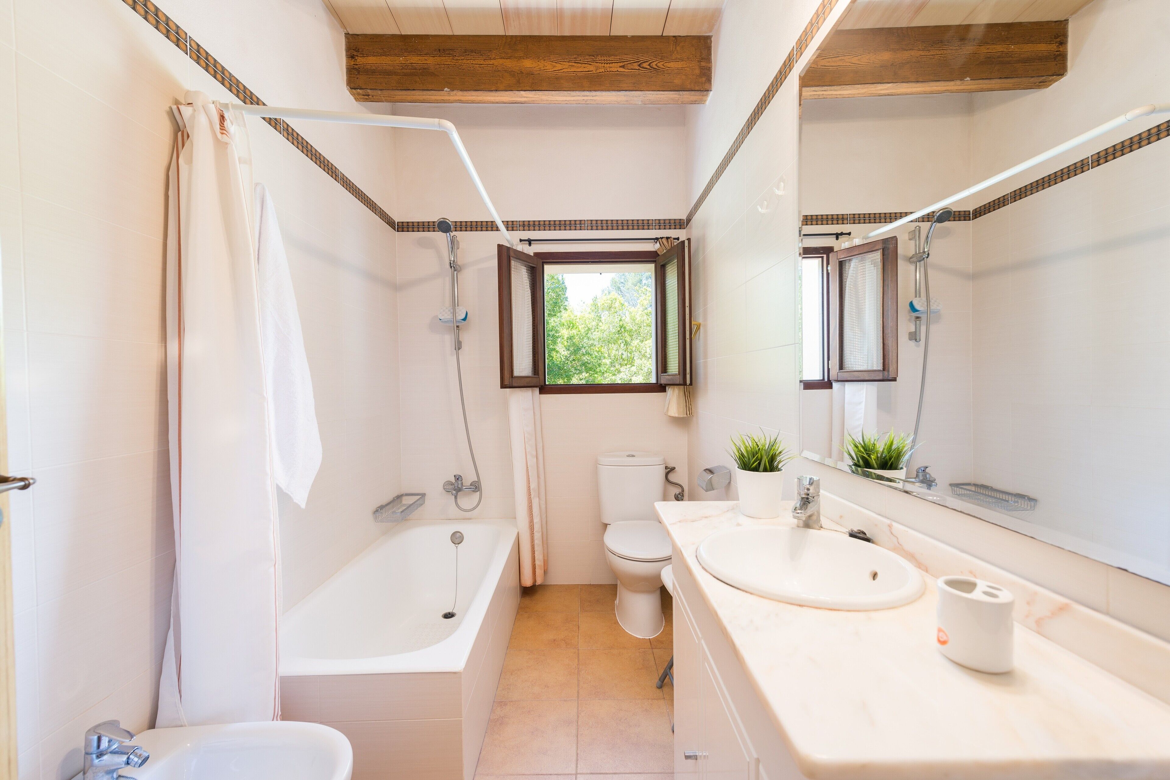 Een bad/douchecombinatie, een haardroger, een bidet, handdoeken