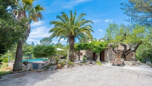A courtyard with a pool, palm trees, stone buildings, and outdoor seating. - CAN COMPANY - Villa with private pool in Campanet. Free WiFi (Campanet)