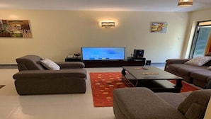 A living room with two sofas, a coffee table, and a flat-screen TV.