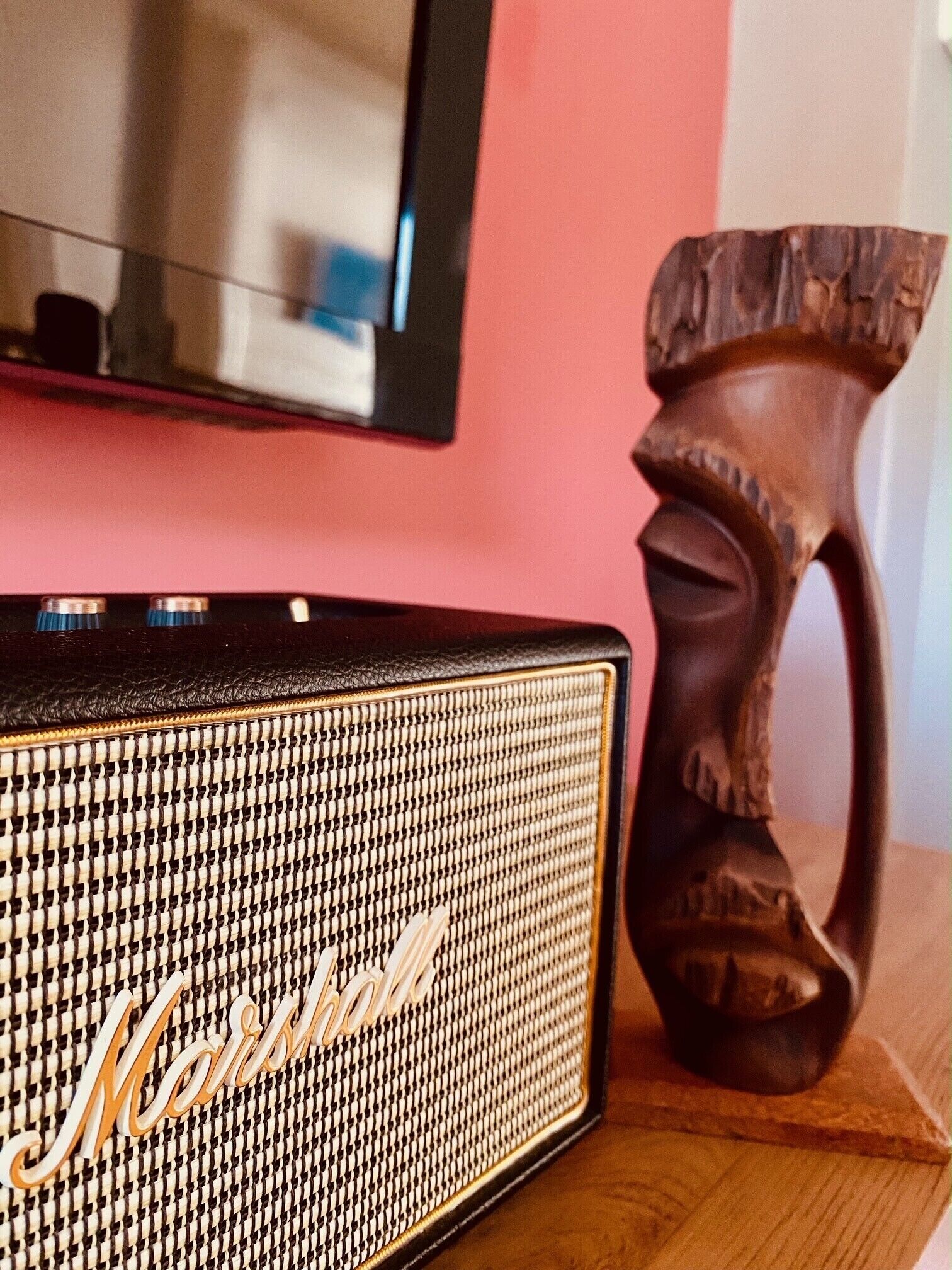 Un haut-parleur en bois portant la marque « Marshall », posé sur une surface en bois.