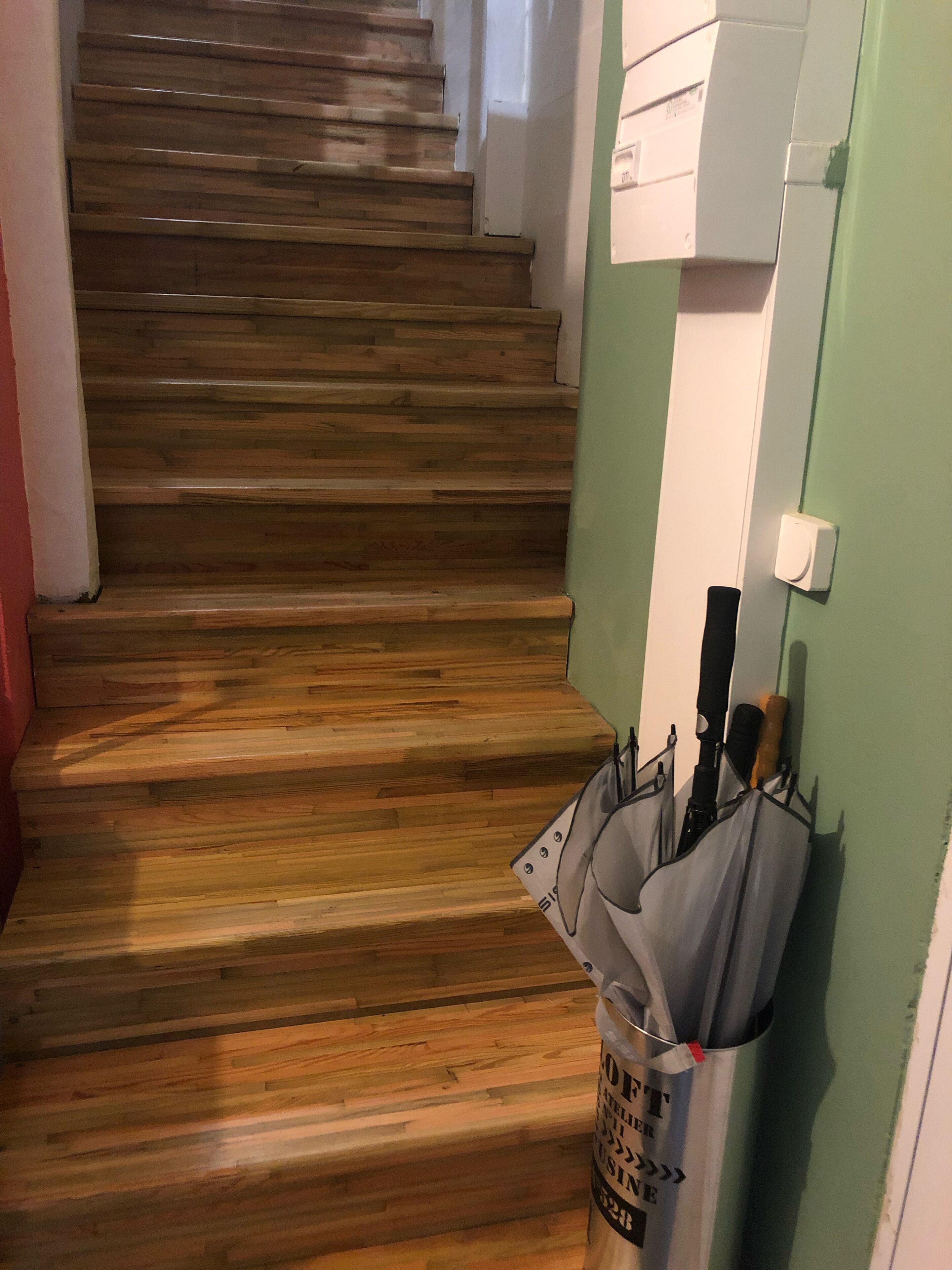 Eine Holztreppe mit einem Müllbeutel auf der rechten Seite.