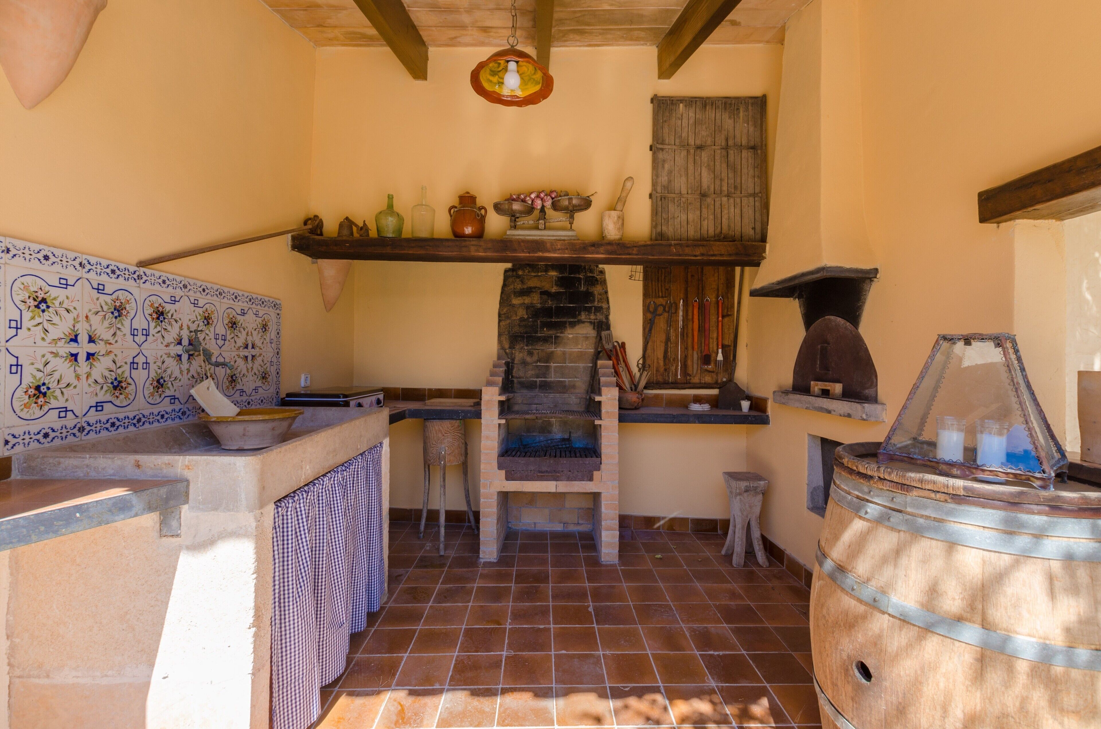 Una cocina rústica con horno de ladrillo, salpicadero de azulejos y estanterías de madera.