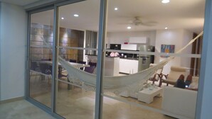 A modern interior with a hammock, a kitchen, and a dining area.