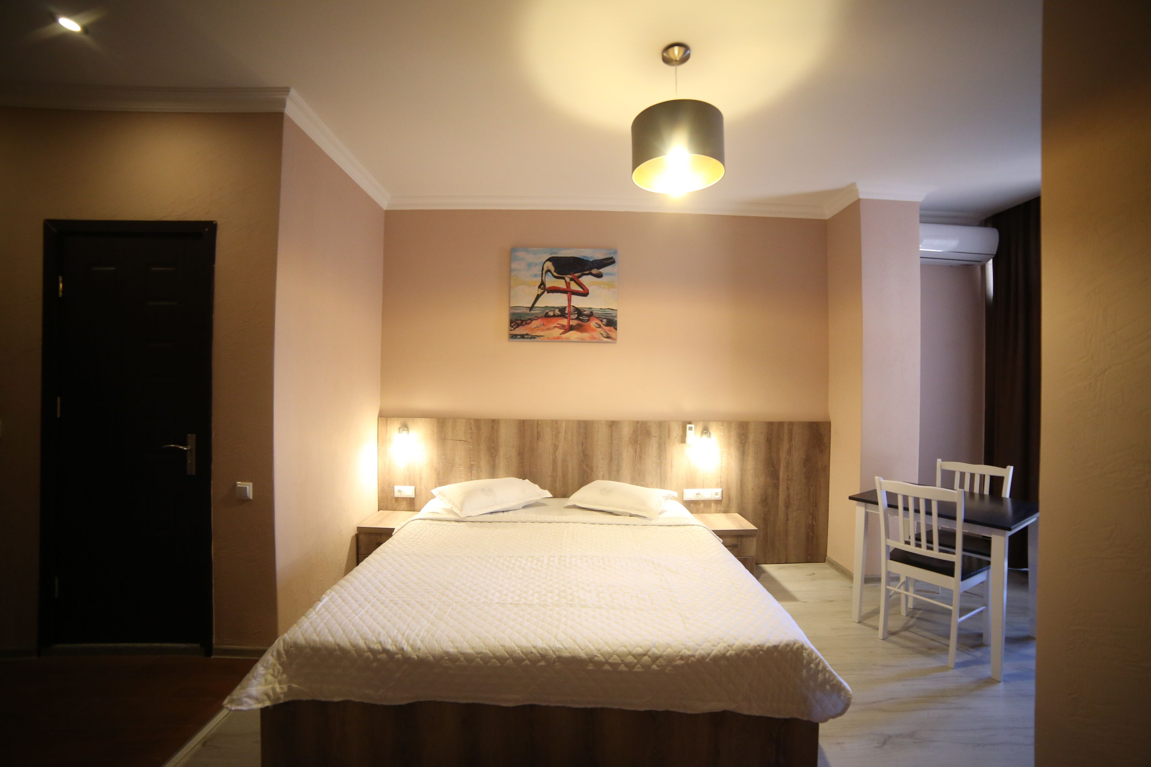 Une chambre d’hôtel avec un lit, des lampes de chevet, un bureau et une chaise.