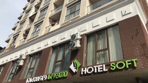 A multi-story hotel building with balconies, air conditioning units, and a sign that reads "HOTEL SOFT". - Hotel Soft (Batumi)