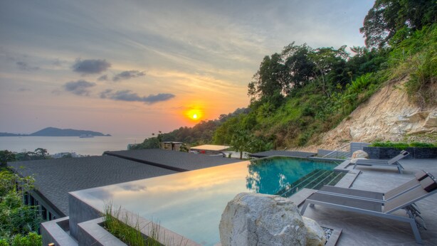 A modern infinity pool with a view of the sunset and a distant island. - Ocean Rock Kalim (Patong)